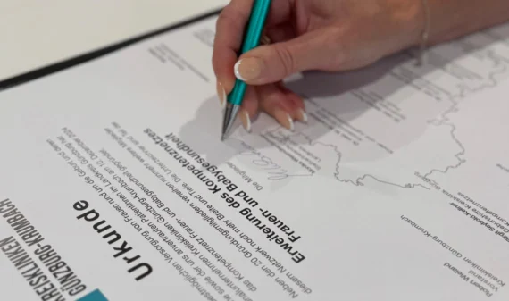 Erweiterung Kompetenznetz Frauen- und Babygesundheit - Hand mit Unterschrift und Stift